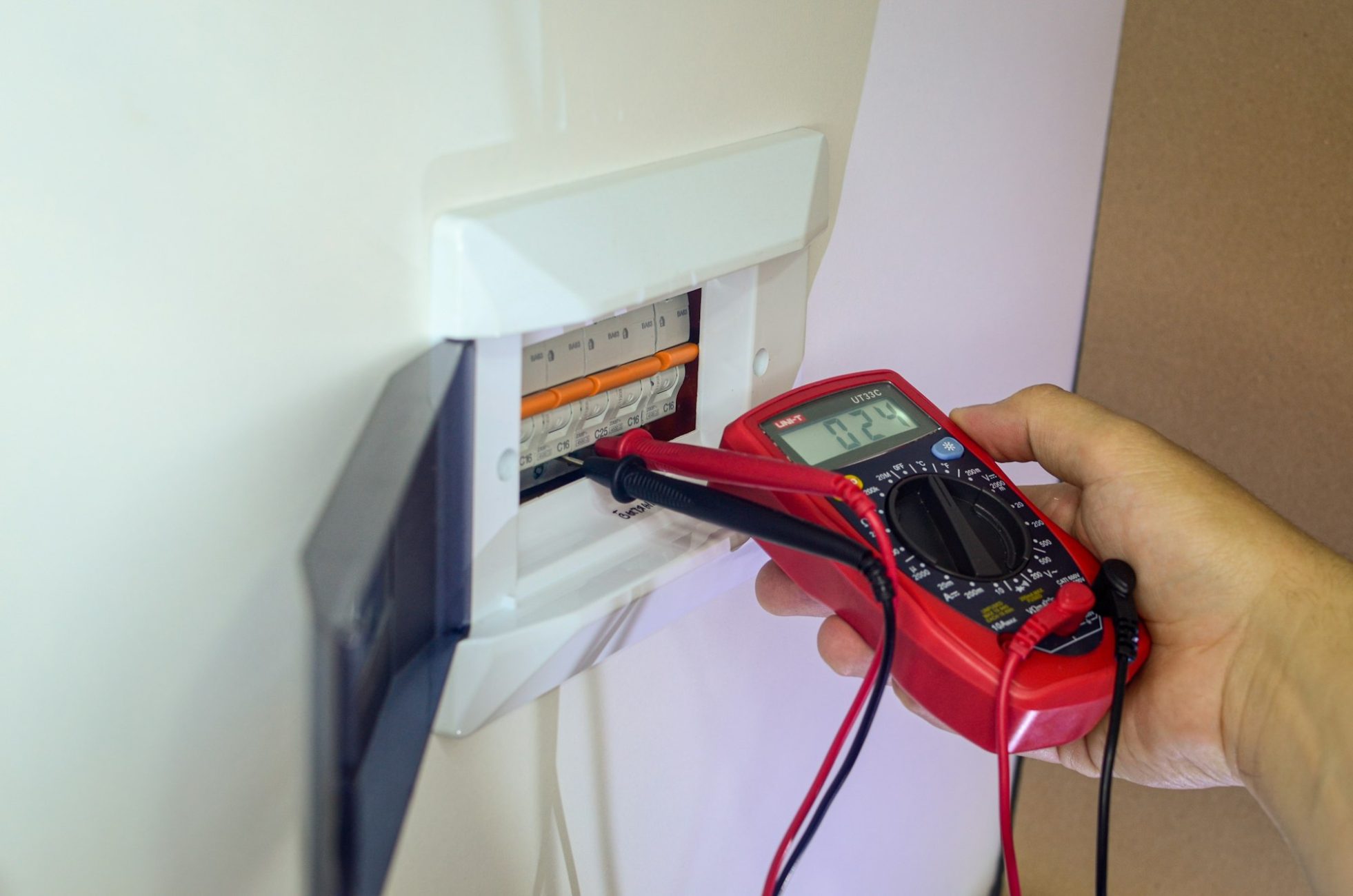 an electrician is repairing an electrical panel. electrical repair. network voltage measurement